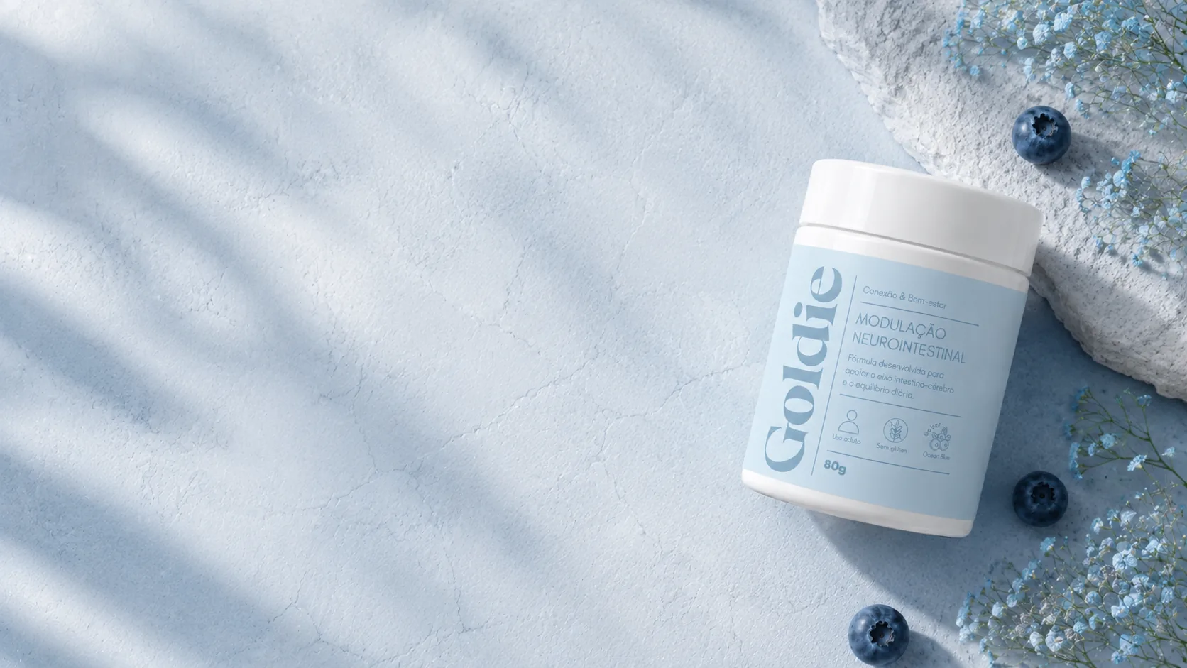 Pote Goldie Modulação Neurointestinal visto de cima sobre superfície azul clara